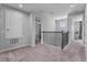 Bright hallway with carpet and railing leads to other rooms in the house, creating an open and inviting transition space at 1224 Hillcrest View Loop, Apopka, FL 32703