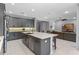 A modern, eat-in kitchen with gray cabinets, a large island, stainless steel appliances, and an open layout to the living room at 1224 Hillcrest View Loop, Apopka, FL 32703