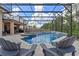 Gorgeous pool and spa area with screened enclosure in a lush backyard setting at 1224 Hillcrest View Loop, Apopka, FL 32703