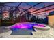 Backyard pool and spa under a screened enclosure, featuring a waterfall and colorful lighting for evening enjoyment at 1224 Hillcrest View Loop, Apopka, FL 32703