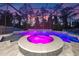 Beautiful screened-in pool with a spa and waterfall features, illuminated with colorful lights at 1224 Hillcrest View Loop, Apopka, FL 32703