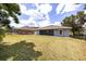 Expansive backyard featuring a well-maintained lawn and clear view of the home's screened-in porch and exterior at 13848 Vista Del Lago Blvd, Clermont, FL 34711