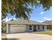 Charming single-story home showcasing a well-maintained lawn, two car garage and inviting arched windows at 13848 Vista Del Lago Blvd, Clermont, FL 34711