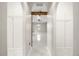 Bright hallway with arched doorways, tiled floors, and custom shelving leads to a spacious room with a view at 13848 Vista Del Lago Blvd, Clermont, FL 34711