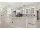 Bright open kitchen with white cabinets, tile backsplash, stainless steel appliances, and bar seating at 13848 Vista Del Lago Blvd, Clermont, FL 34711