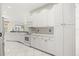 Open kitchen featuring white cabinets, tile backsplash, stainless steel appliances, and white tile floors at 13848 Vista Del Lago Blvd, Clermont, FL 34711