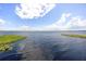 Expansive lake view showcasing blue water and sky with scattered clouds and shoreline grasses at 13848 Vista Del Lago Blvd, Clermont, FL 34711