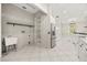 Bright laundry room adjacent to kitchen with white cabinets, shelving, and stainless steel appliances at 13848 Vista Del Lago Blvd, Clermont, FL 34711