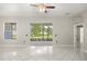 Bright living space showcasing ceramic tile floors, a ceiling fan, with views of the lanai and backyard at 13848 Vista Del Lago Blvd, Clermont, FL 34711