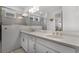 Bright bathroom featuring double sinks, white cabinetry, quartz counters and tiled shower at 15133 Summer Harvest St, Winter Garden, FL 34787
