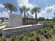 Stone sign for Harvest at Ovation community with lush landscaping and palm trees at 15133 Summer Harvest St, Winter Garden, FL 34787