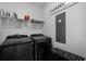 Modern laundry room with washer, dryer, shelving, and dark cabinets for storage at 15133 Summer Harvest St, Winter Garden, FL 34787