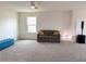 Spacious bonus room with plush carpeting, comfortable sofa, and ample natural light at 1588 Sky Lakes Dr, St Cloud, FL 34769