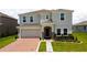 Charming two-story home features a brick driveway, two-car garage, and a well-manicured lawn at 1588 Sky Lakes Dr, St Cloud, FL 34769