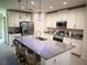 A modern kitchen boasts a granite island with seating, stainless steel appliances, and stylish pendant lighting at 1588 Sky Lakes Dr, St Cloud, FL 34769