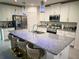A modern kitchen boasts a granite island with seating, stainless steel appliances, and stylish pendant lighting at 1588 Sky Lakes Dr, St Cloud, FL 34769