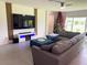 Cozy living room featuring a large sectional sofa, stylish ottoman, mounted TV, and a festive Christmas tree at 1588 Sky Lakes Dr, St Cloud, FL 34769