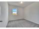 Neutral bedroom with gray carpet, a ceiling light, and a window overlooking a view at 172 S Zuni Rd, St Cloud, FL 34771
