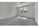 Inviting bedroom featuring soft carpeting, two bright windows, and a neutral color scheme for a calming atmosphere at 172 S Zuni Rd, St Cloud, FL 34771