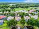 Beautiful aerial shot of a residential property with a screened pool, mature trees, and a tranquil pond nearby at 174 Promenade Cir, Lake Mary, FL 32746