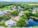 Stunning aerial view of a home with a private pool, lush landscaping, and proximity to a picturesque lake and golf course at 174 Promenade Cir, Lake Mary, FL 32746