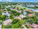 Aerial view of a well-maintained home surrounded by mature trees, near a golf course and scenic pond with a fountain at 174 Promenade Cir, Lake Mary, FL 32746