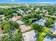 Overhead shot of a house with lush greenery and community amenities, including a pond with fountain and a golf course at 174 Promenade Cir, Lake Mary, FL 32746
