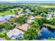 Stunning aerial view of a home with a private pool, lush landscaping, and proximity to a picturesque lake and golf course at 174 Promenade Cir, Lake Mary, FL 32746