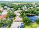 Aerial perspective of a home featuring lush greenery, a nearby pond with fountain, and a golf course in the distance at 174 Promenade Cir, Lake Mary, FL 32746