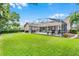 Expansive backyard with a covered patio, lush green lawn, and mature landscaping at 174 Promenade Cir, Lake Mary, FL 32746