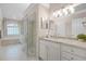 Bathroom showcasing a glass-enclosed shower, a soaking tub and a vanity with marble countertops and modern fixtures at 174 Promenade Cir, Lake Mary, FL 32746