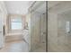 Bathroom featuring a glass shower, tub, and tiled walls, creating a spa-like experience with natural lighting at 174 Promenade Cir, Lake Mary, FL 32746