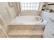 Bathroom featuring a soaking tub with tile surround and window, offering a relaxing retreat at 174 Promenade Cir, Lake Mary, FL 32746