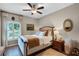 Cozy bedroom with a ceiling fan, wooden floors, and a comfortable bed with decorative pillows and warm lighting at 174 Promenade Cir, Lake Mary, FL 32746