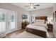 Well-lit bedroom with wood-look flooring, large bed, and French doors at 174 Promenade Cir, Lake Mary, FL 32746