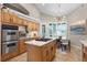 Bright kitchen features stainless appliances, island cooktop, breakfast nook, and wood cabinetry at 174 Promenade Cir, Lake Mary, FL 32746