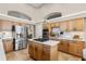 Gourmet kitchen with stainless appliances, island cooktop, and warm wood cabinetry at 174 Promenade Cir, Lake Mary, FL 32746