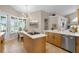 Open floor plan with kitchen island cooktop and dining area with natural lighting at 174 Promenade Cir, Lake Mary, FL 32746