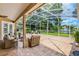 Screened-in lanai with brick pavers, water view, and comfortable seating, perfect for outdoor enjoyment at 174 Promenade Cir, Lake Mary, FL 32746