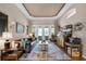 Bright living room boasting tray ceilings, lots of comfortable seating, and elegant decor at 174 Promenade Cir, Lake Mary, FL 32746