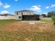 A spacious backyard with a screened patio and ample green space, enclosed by a white fence at 1793 Western Hills Ln # N, Mascotte, FL 34753
