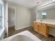 Bathroom featuring a soaking tub, a vanity with storage, and wood-look flooring at 1793 Western Hills Ln # N, Mascotte, FL 34753