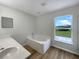 Bright bathroom with a soaking tub, a large window with a view, and a modern vanity and sink at 1793 Western Hills Ln # N, Mascotte, FL 34753