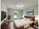Comfortable bedroom features neutral walls, wood furniture and a window with plenty of natural light at 1793 Western Hills Ln # N, Mascotte, FL 34753