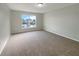 Cozy bedroom features a large window providing natural light, with a neutral color scheme and plush carpeted floors at 1793 Western Hills Ln # N, Mascotte, FL 34753