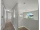 Upstairs hallway with carpet, neutral paint, unique arched pass-throughs, and a window overlooking the neighborhood at 1793 Western Hills Ln # N, Mascotte, FL 34753