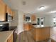Well-equipped kitchen features modern appliances, wood cabinets, and an island that opens to the living area at 1793 Western Hills Ln # N, Mascotte, FL 34753