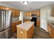 Well-lit kitchen featuring light wood cabinets, an island, and stainless steel refrigerator at 1793 Western Hills Ln # N, Mascotte, FL 34753