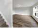 Well-lit living area featuring wood floors, freshly painted white walls, and a view from the staircase at 1793 Western Hills Ln # N, Mascotte, FL 34753