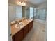 Bathroom showcasing double sinks, vanity, and a tub with glass enclosure at 1984 Estancia Circle # 29A, Kissimmee, FL 34741